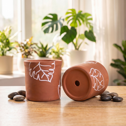 Two terracotta planters with drainage holes for aeration